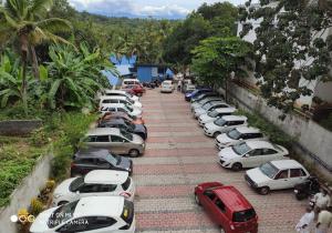 una fila de autos estacionados en un estacionamiento en Harisuns Plaza, en Attingal