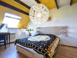 een slaapkamer met een bed en een kroonluchter bij Holiday home in nature near D cize in Decize