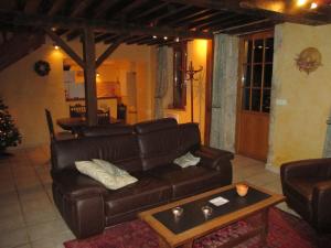 sala de estar con sofá de cuero y mesa en Pretty holiday home with garden near forest, en Isenay