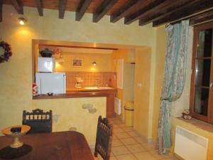 cocina y comedor con mesa y nevera en Pretty holiday home with garden near forest, en Isenay