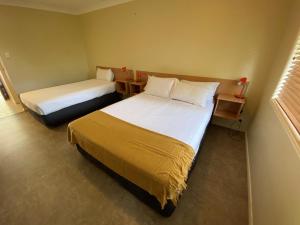 a hotel room with two beds and two lamps at Country Roads Motor Inn Gayndah in Gayndah