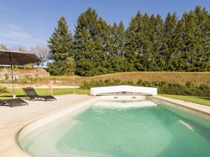 una piscina con due sedie e un ombrellone di Luxury villa with pool on the edge of Montignac a Montignac