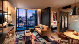 a living room with a couch and a table at Hotel Indigo Adelaide Markets by IHG in Adelaide