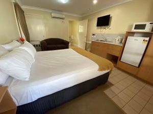 a hotel room with two beds and a television at Country Roads Motor Inn Gayndah in Gayndah