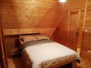 sypialnia w drewnianym domku z łóżkiem w obiekcie Emilijin konak w mieście Kokin Brod