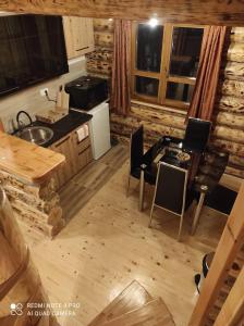 a kitchen with a table and chairs in a cabin at Emilijin konak in Kokin Brod