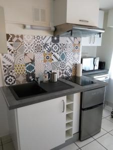 cocina con fregadero y pared de azulejos en Nantes - Calme & Cosy appartement - WIFI, en Nantes