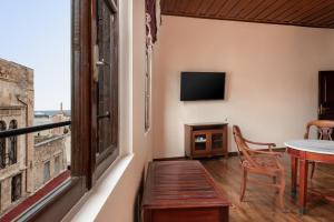 Habitación con balcón con mesa y ventana. en Old Town Suites en La Canea