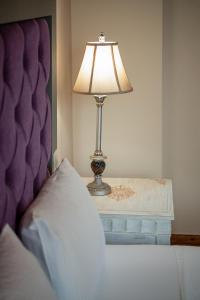 a lamp sitting on a table next to a bed at Old Town Suites in Chania