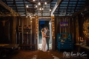 a bride and groom standing in the doorway of a barn at Dingup House in Manjimup