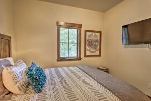 1 dormitorio con 1 cama con almohadas y TV en Walk to Main St and Marina Grand Lake Cabin!, en Grand Lake