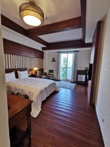 仁愛鄉的住宿－清境羊角村鄉村民宿，一间卧室配有一张床、一张桌子和一个窗户。