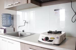 una cucina con tostapane su un bancone accanto a un lavandino di Simply 1BR Apartment at Stanford Jatinangor By Travelio a Sayang