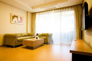 een woonkamer met een bank en een tafel bij STX Resort in Mungyeong