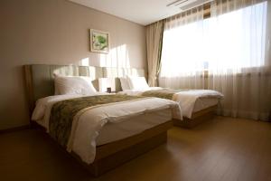 Cette chambre comprend 2 lits et une fenêtre. dans l'établissement STX Resort, à Mungyeong