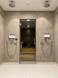 a bathroom with two shower stalls in a building at Hotel Fabrik Forssa in Forssa