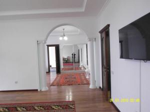a hallway with white walls and a flat screen tv at Vip апартаменты три квартиры на одной площадке одна 3х комнатная с 2мя санузлами площадью 140м2 две 2х комнатные площадью по 100м2 in Shymkent