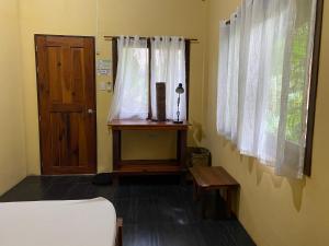 a room with a bed and a chair in it at Ilakai Hostel in General Luna