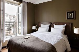 a bedroom with a large bed with a large window at Hotel Rochechouart - Orso Hotels in Paris