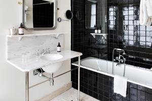 a bathroom with a tub and a sink and a bath tub at Hotel Rochechouart - Orso Hotels in Paris
