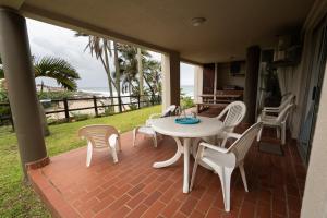 a table and chairs on a patio with a view of the ocean at Laguna La Crete 87 in Uvongo Beach