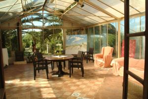 un salón acristalado con mesa y sillas en una habitación en Son Baulo en Lloret de Vistalegre