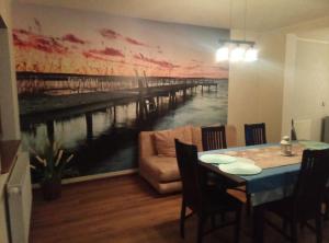 a dining room with a painting of a pier at Cały dom do dyzpozycji in Boszkowo