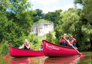 Un groupe de personnes en bateau rouge sur une rivière dans l'établissement NATURAMA BEILNGRIES - SchäferwagenDorf, à Beilngries