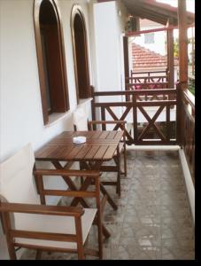 a wooden table and chairs sitting on a balcony at Hotel Sarandos in Ammouliani