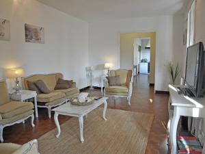 uma sala de estar com um sofá, uma mesa e uma televisão em Quiet villa near the beach at Fr jus em Fréjus