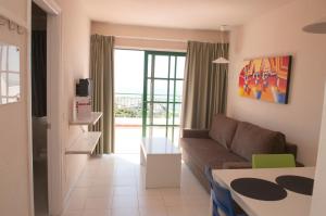 un soggiorno con divano e tavolo di Apartamentos Babalu a Puerto Rico de Gran Canaria