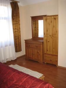 a bedroom with a wooden cabinet and a dresser at Amber Cottage in Jūrmala
