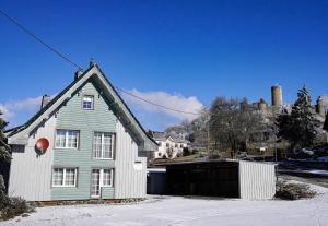 a house with a garage in the snow at Gästehaus Fuchshof in Nürburg