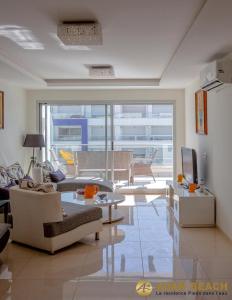 a living room with a couch and a tv and a table at Adan Beach Residence, Beach Front Apartments in Aourir