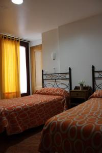 ムルシアにあるペンション セグラのベッド2台と窓が備わるホテルルームです。