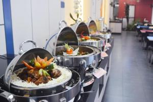 a row of food pans lined up in a row at Amaris Hotel Cimanuk Bandung in Bandung