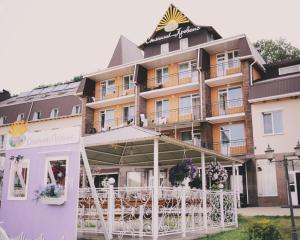 a hotel with tables and chairs in front of it at VitaPark Sonyachnyy Provans in Satanov