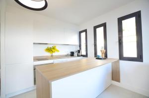 a kitchen with white cabinets and a wooden counter top at La Perle d'Eze - Aparthotel in Éze