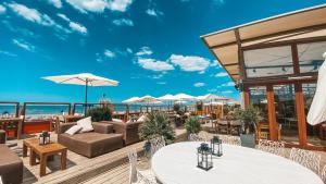 a patio with tables and chairs and a view of the ocean at Finca Noordwijk met privé tuin, dichtbij strand in Noordwijk