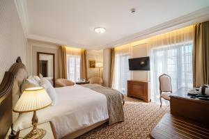 een hotelkamer met een bed en een televisie bij Residence City Garden - Certificate of Excellence 3rd place in Top 10 BEST Five-Stars City Hotels for 2023 awarded by HTIF in Plovdiv