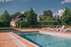 einen Pool mit zwei Stühlen und ein Haus in der Unterkunft Matild Country Hotel in Nemesvita