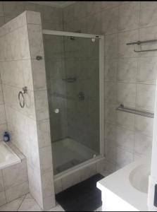 eine Dusche mit Glastür im Bad in der Unterkunft Kosmos Lodge in Hartbeespoort