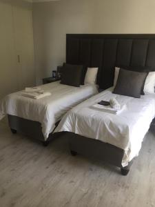 ein Schlafzimmer mit einem großen Bett mit einem großen Kopfteil in der Unterkunft Kosmos Lodge in Hartbeespoort