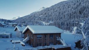 une cabine avec neige sur le toit en face d'une montagne dans l'établissement ARLBERGhome, à Wald am Arlberg