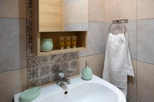 a bathroom with a white sink and a towel at Ririka Athens Homes - Cosy Apartments in Monastiraki, Athens Historical Centre in Athens