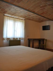 Schlafzimmer mit einem Bett, einem Fenster und einem Tisch in der Unterkunft Casa Dona' Penne in Penne