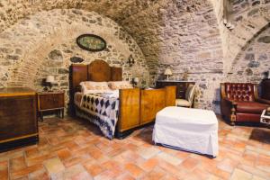 a bedroom with a bed and a couch in a room at Dimora Pietrantica in Rocca Imperiale