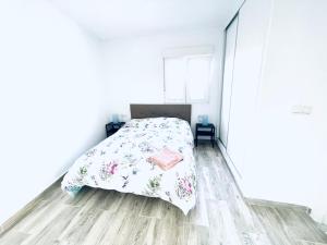 a white bedroom with a bed and a wooden floor at Super Exclusive Bungalow in Benalmádena +12 photos