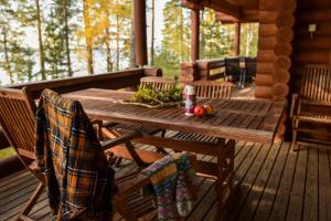 a wooden table and chairs on the porch of a cabin at Lomalehto Cottages in Kiviapaja