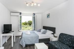 una camera con letto, divano e finestra di Apartment Tetepave a Dubrovnik